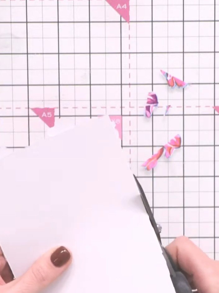 Step 10: Trim away the excess paper from around the arranged flowers using scissors, carefully cutting close to the edg
