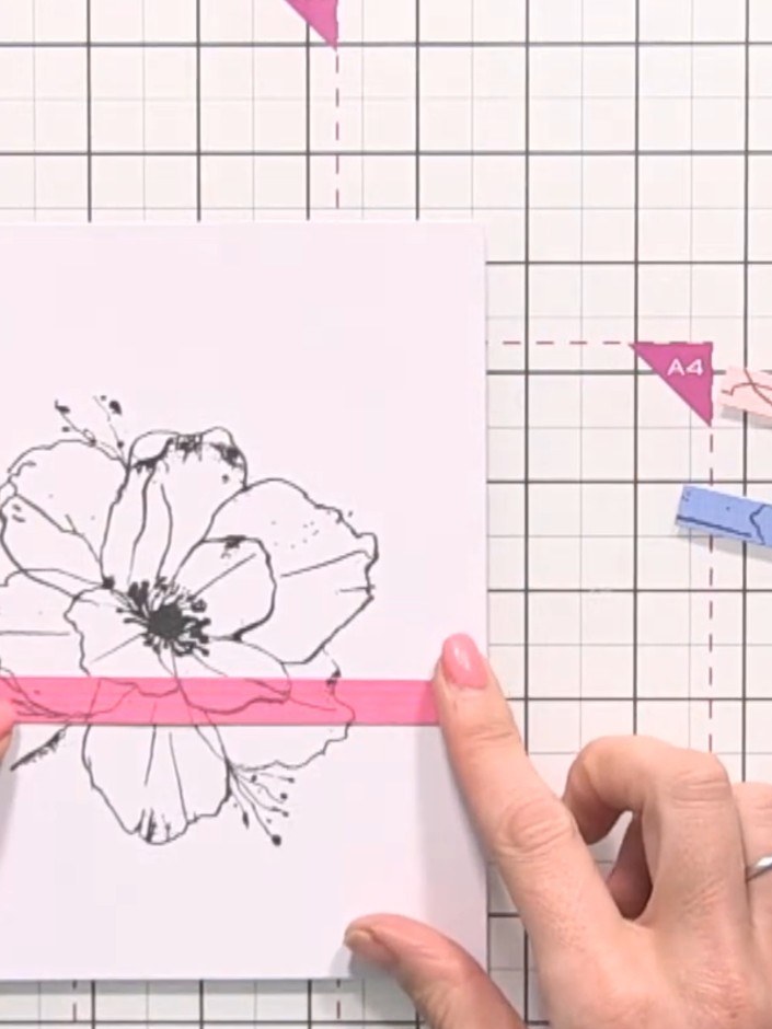 Step 5: Position the pink strip horizontally across the centre of the flower design on your card base, ensuring the de