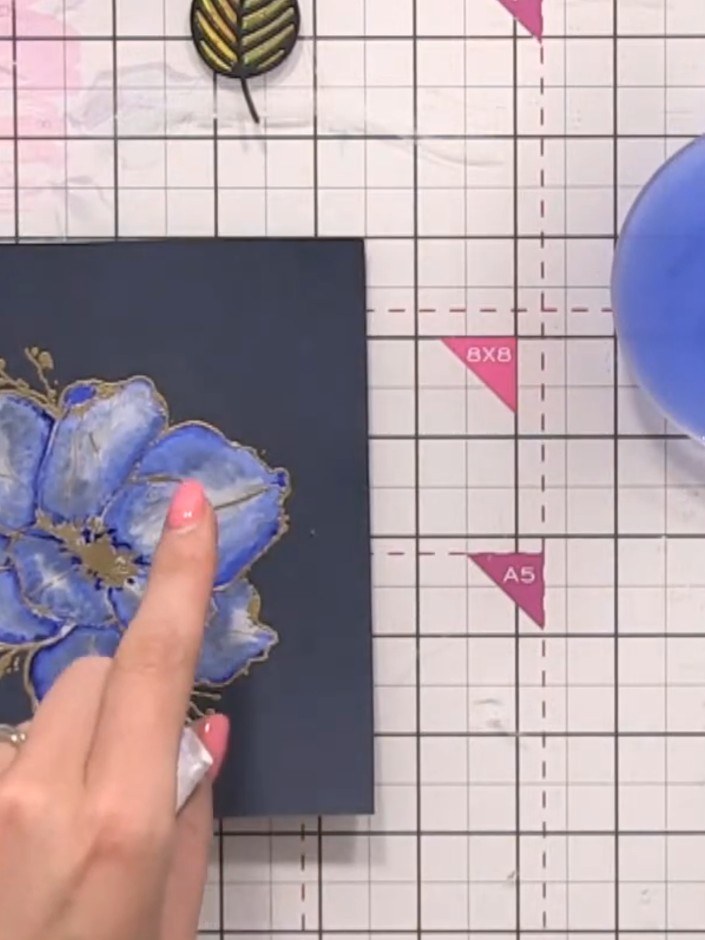 Step 13: Mach deinen Pinsel nass und setz goldene Farbspritzer rund um die Blume – als dekorative Akzente.