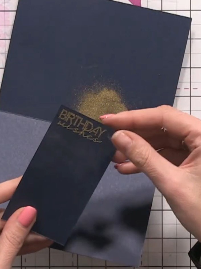 Step 16: Heat set the sentiment using a heat tool. Trim down the sentiment piece and create a small foam pad by stackin