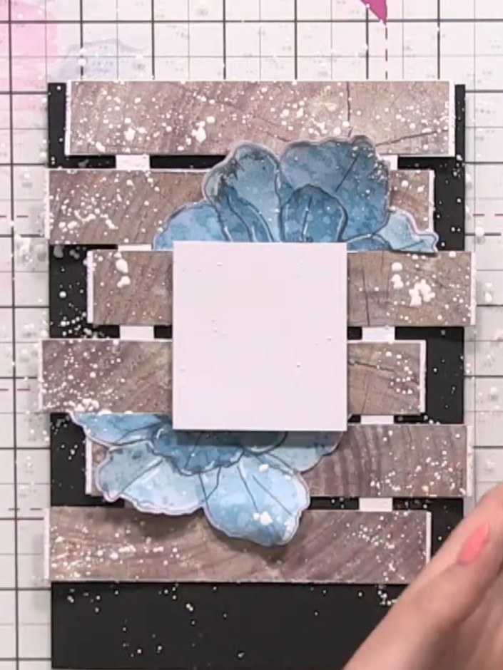 Step 16: Splatter white acrylic paint across the finished card using a wet brush to add final distressed texture. Allow