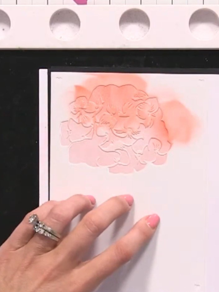 Step 6: Take the uncut white paper piece with the embossed floral design and pink ink blending. Adhere it to the front