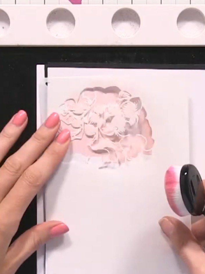Step 3: Position stencil number two over the card and apply the same orange ink using the blending tool, creating a se