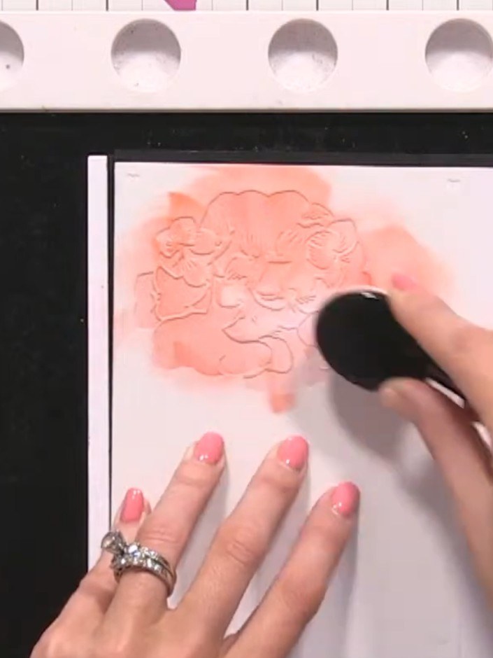 Step 4: Switch to a pink ink and apply it through stencil number three using a blending brush. Dab the ink over the em