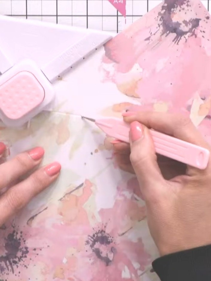 Step 9: Using the pink bone folder, tape the sides of the envelope together securely. Press firmly along the scored li