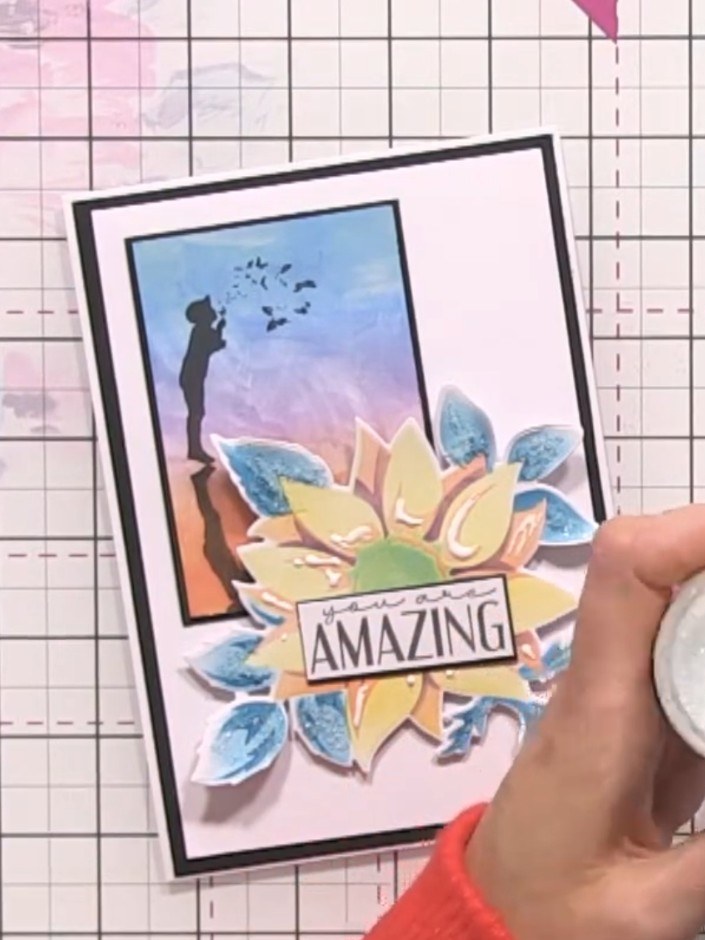 Step 8: Sprinkle colourless media glitter over the glued areas of the card. Tap off the excess glitter back into the p