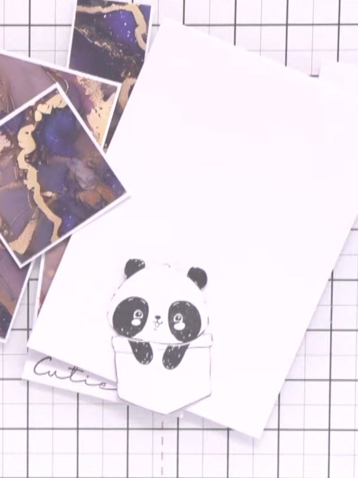 Step 7: Use a blue or grey ink pad with water to shade around the panda's eyes and ears. This creates depth and makes 