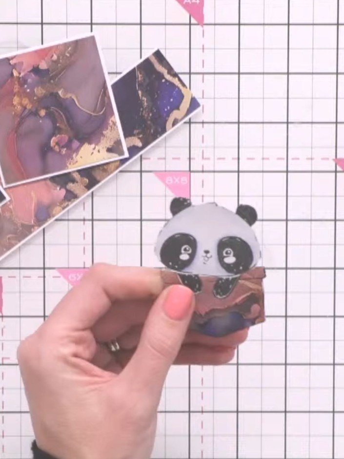 Step 9: Glue the panda character on top of the pocket so it appears to emerge from it. Position the panda centrally ov
