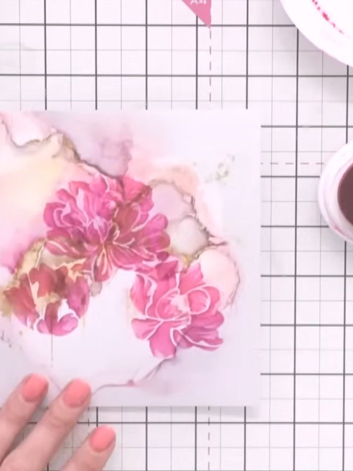 Step 8: Carefully remove the stencil from your card to reveal the completed layered floral design. The pink flowers sh