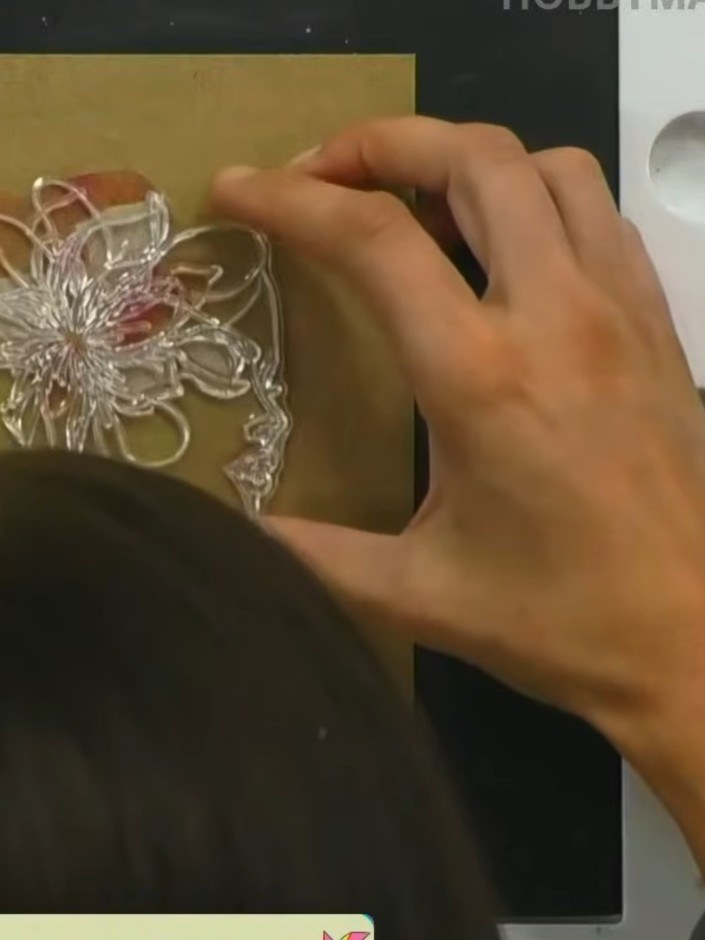 Step 8: Position the clear detail stamp over the coloured flower on the gold card, carefully aligning it with the visi
