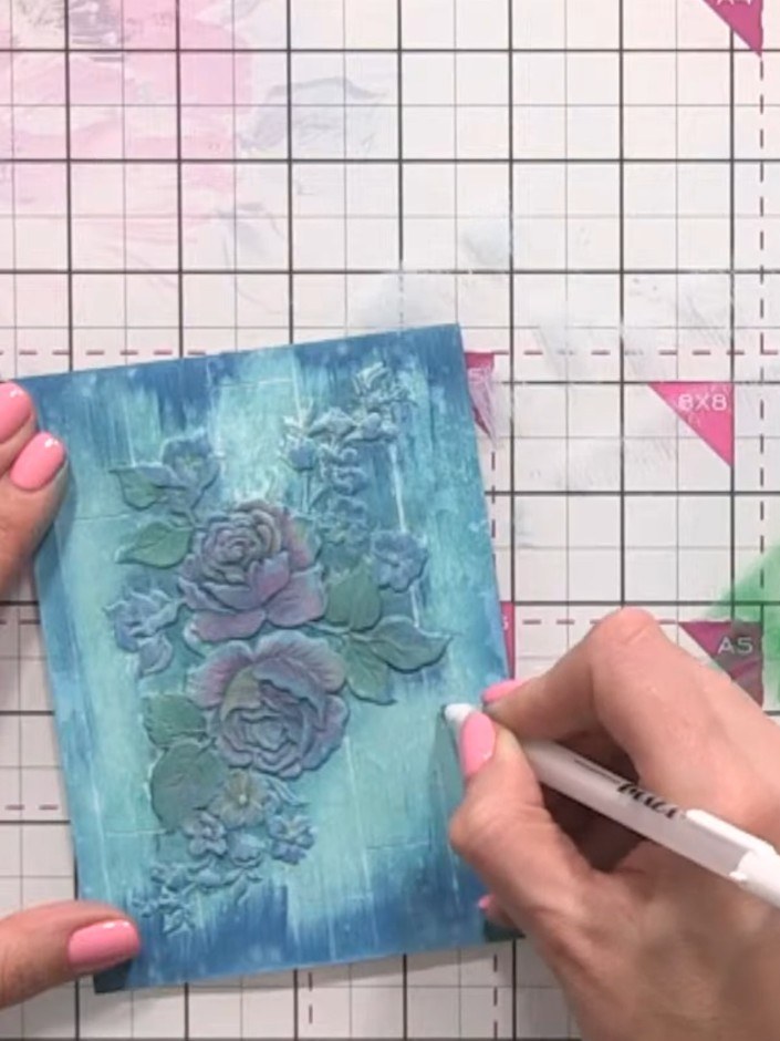 Step 14: Using a white pen or marker, add fine highlights to the embossed roses to make them stand out against the aged