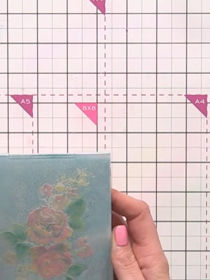 Step 9: Place the painted card back into the inked embossing folder with the white rose design and run it through the 