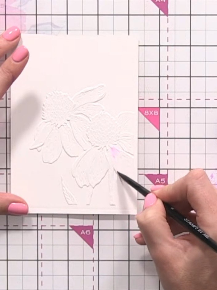 Step 4: Allow the purple watercolour to disperse naturally into the water on the embossed rose petals, creating a soft