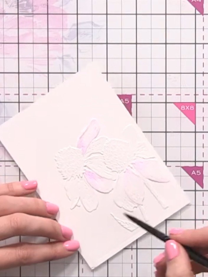 Step 6: Apply a slightly darker shade of purple to the centre of each petal on the embossed rose design to add depth a
