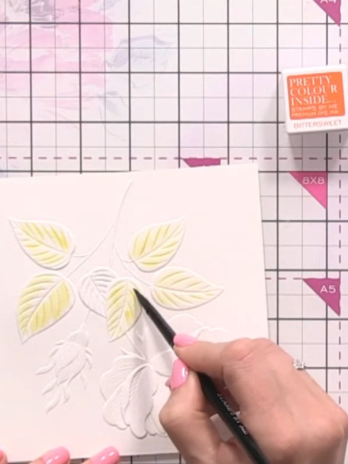 Step 3: Add diluted green ink down the centre and edges of each leaf whilst the yellow is still wet, allowing the colo