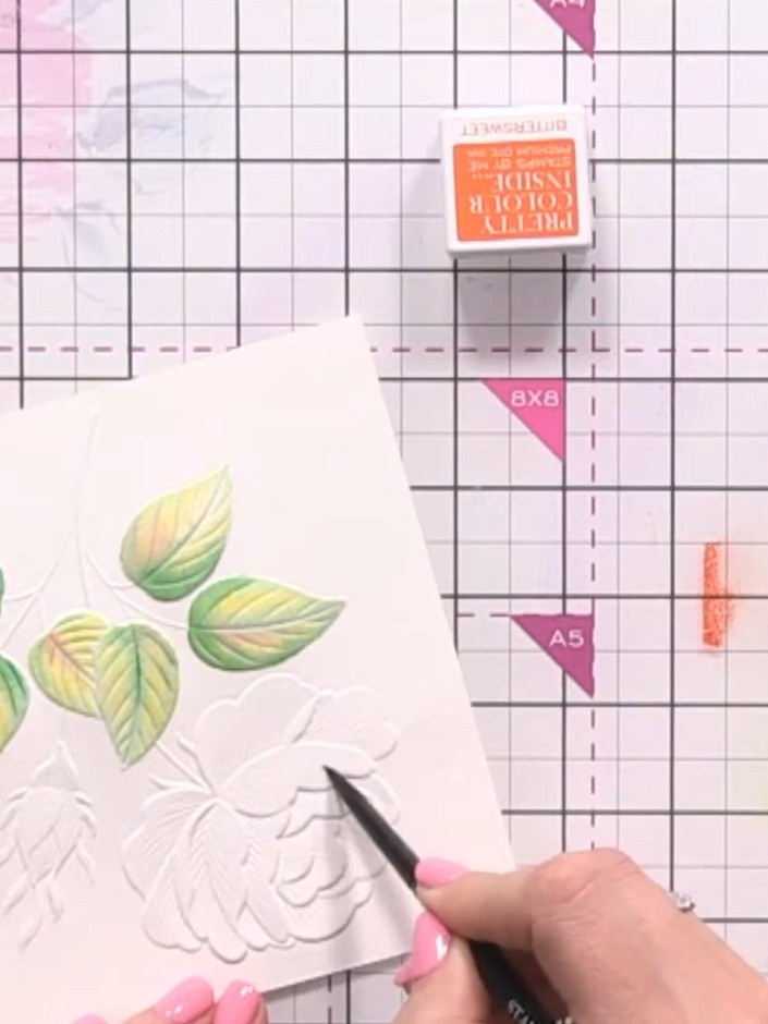 Step 6: Using a clean water brush, wet the first rose petal. Then apply diluted orange ink to the base of the petal an