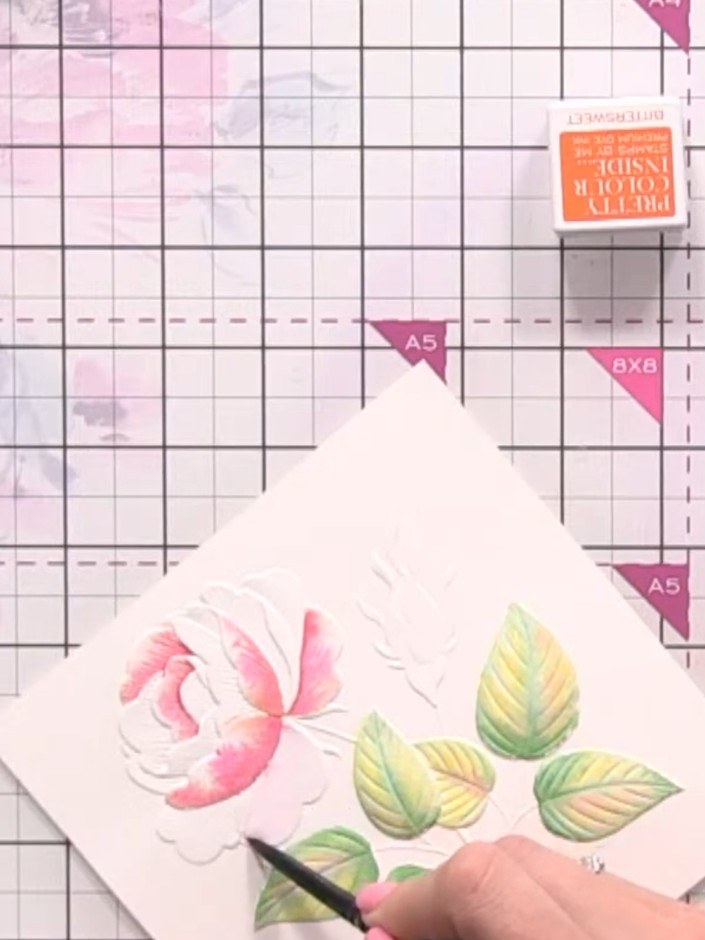 Step 9: Using a wet brush with orange watercolour, add colour to the base of additional petals on the embossed design.