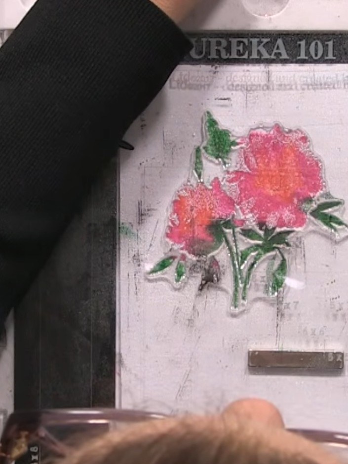 Step 7: Carefully lift the lamination stamp away from the card to reveal the coloured flower image beneath.