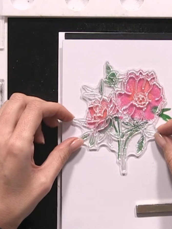 Step 9: Ink the detailed stamp in black ink and press it firmly onto the stamped floral image to add sketched detail l