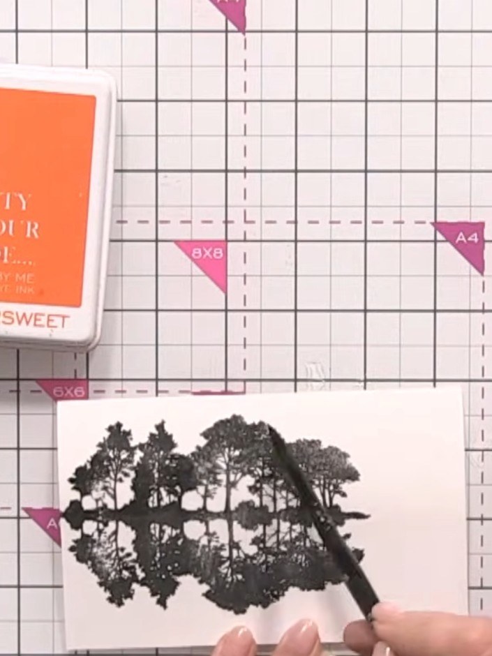 Step 5: Using a flat brush and clean water, wet the top portion of the card above the stamped trees. This will prepare