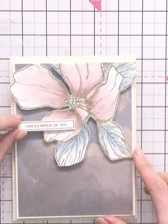 Step 11: Add a sentiment from the back of the colouring book, such as 'I am so proud of you', using double-sided tape o