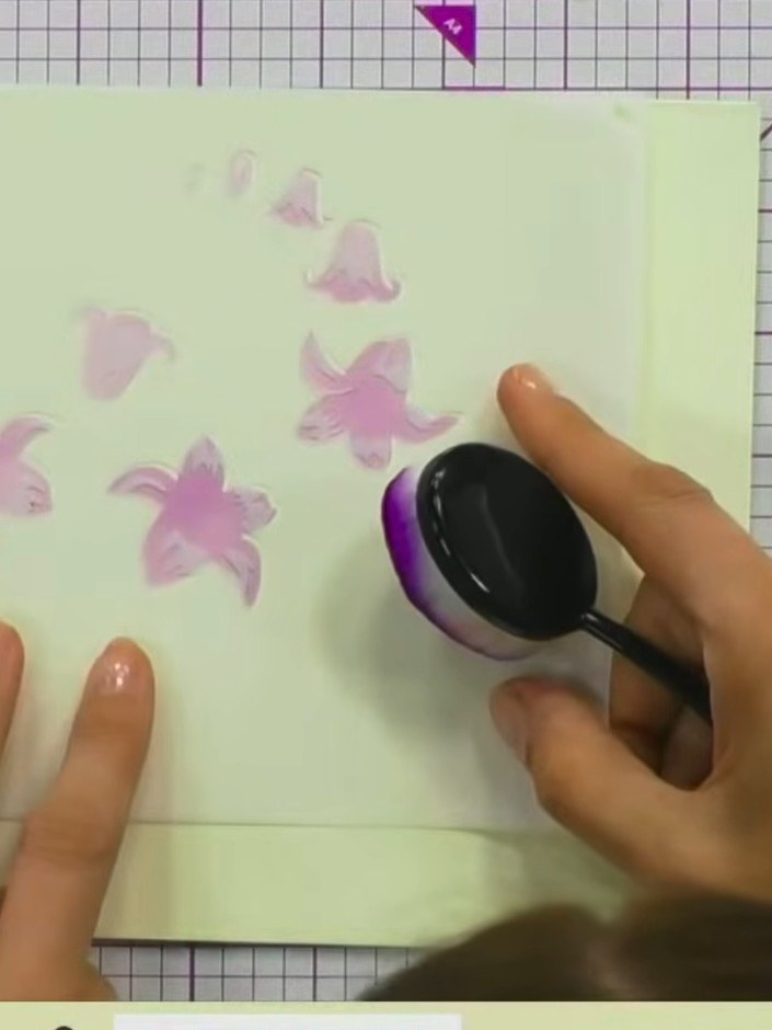 Step 3: Using a purple dye-based ink and a blending tool or sponge, lightly tap the ink through the stencil onto the c