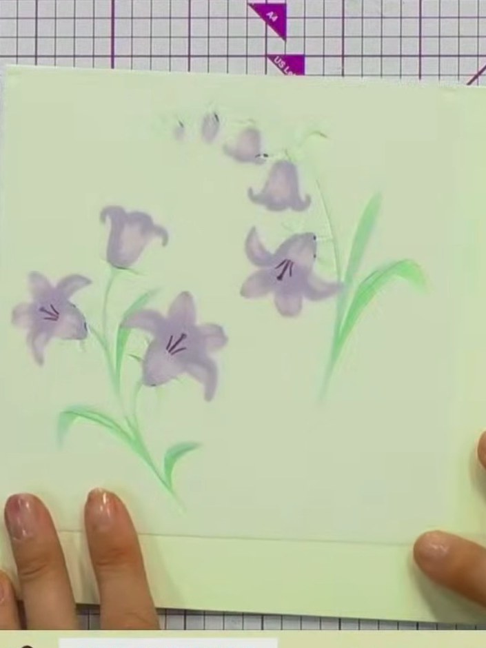 Step 8: Lass die Karte vollständig trocknen, bevor du die Schablonen entfernst. The purple bluebell flowers will appear soft an