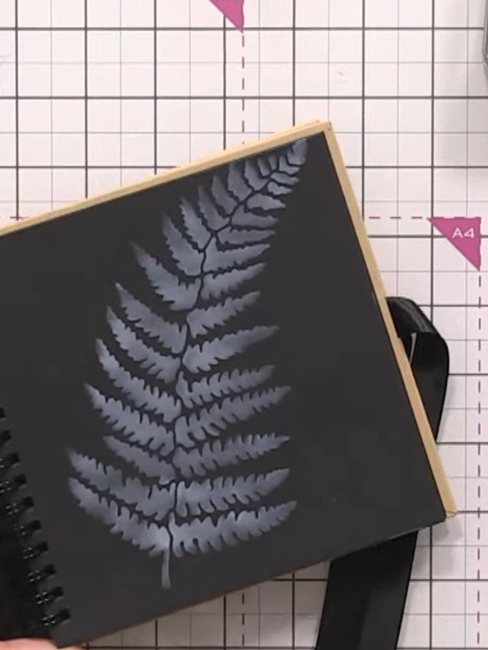 Step 3: Mix the grasshopper confetti ink with water on a glass mat. Using a damp brush, paint over the white fern desi