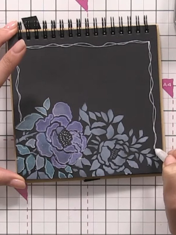 Step 7: Using a white gel pen, draw decorative wonky lines from the floral design to the edges of the page to anchor t