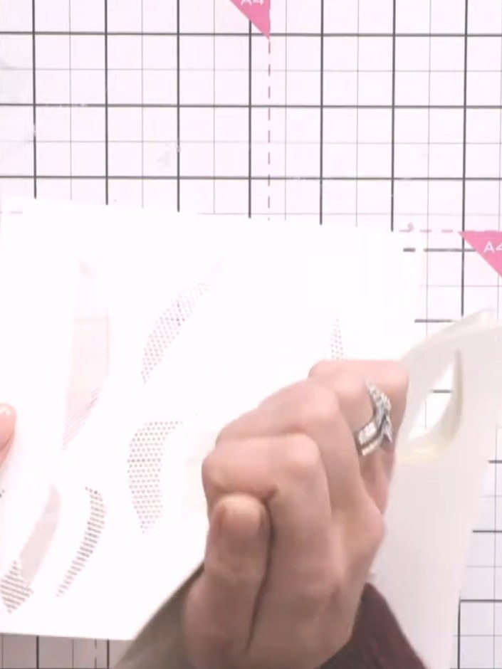 Step 2: Select stencil number one from the Dotted Tulips set and position it along the edge of your card base on the c