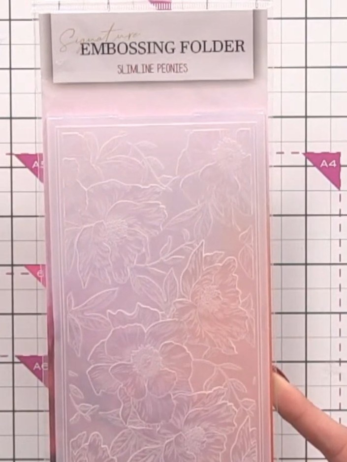 Step 1: Position your patterned paper from the Wildflower Sunset collection into the slimline peonies embossing folder