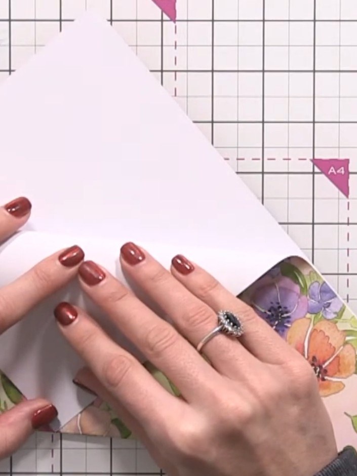 Step 4: Pull the top point of the folded paper down to align with the centre line. Press firmly along the fold to crea