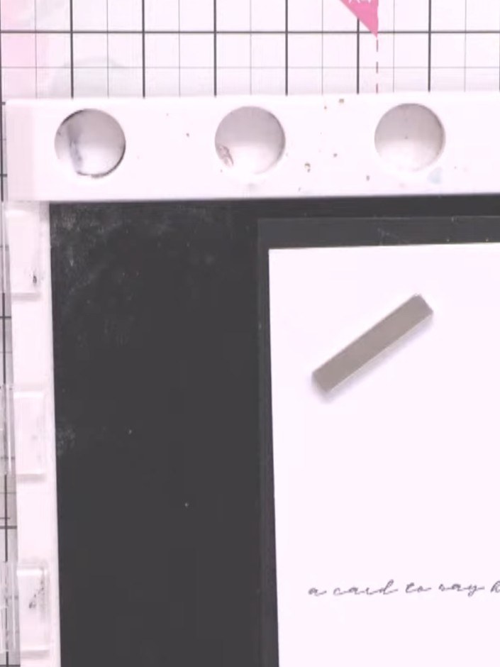 Step 5: Position one torn paper strip flat onto the white card base, placing it horizontally beneath the stamped silho