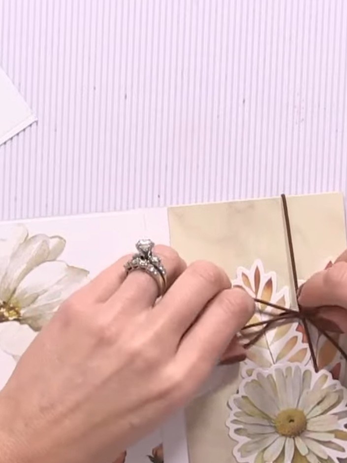 Step 13: Wrap elastic around the album spine and tie it in a bow on the front cover to create a closure and add decorat