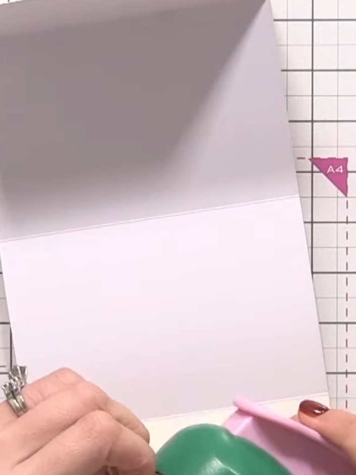Step 9: Use the 2-inch circle punch to punch half circles along the folded edge of another white card section, creatin