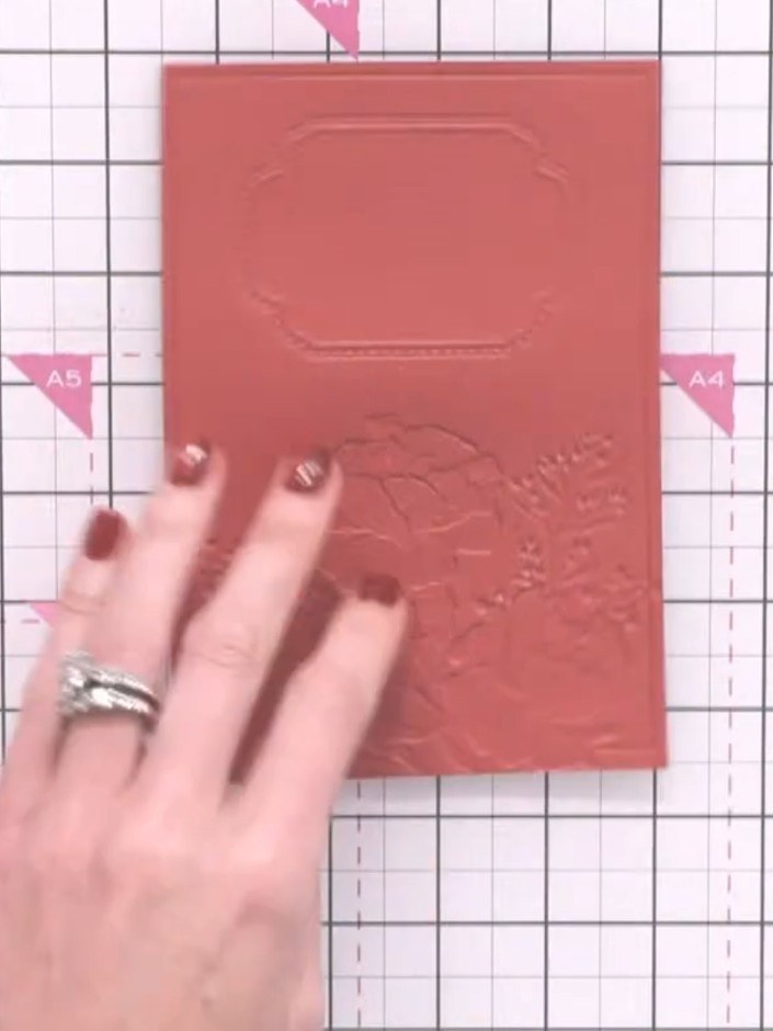 Step 7: Apply white embossing ink to the raised embossed areas of the red cardstock using a white ink pad. Gently dab 