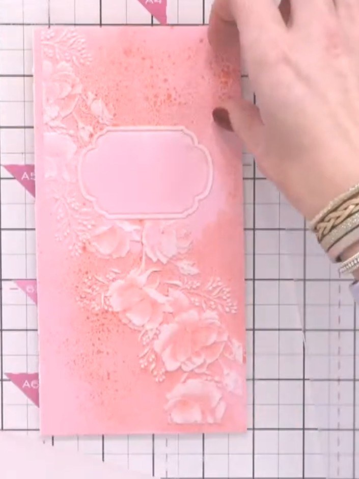 Step 5: Position your pink cardstock on top of the embossing folder, ensuring it is centred over the design. The embos