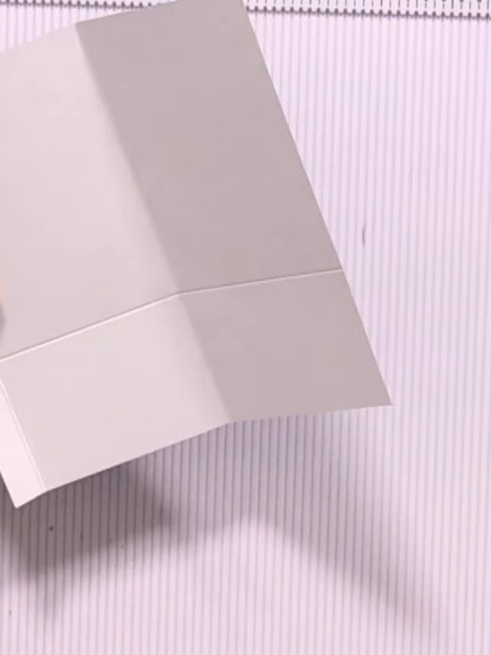 Step 6: Fold both flaps inward to create your front pocket. The grey patterned panels should fold in to meet at the ce