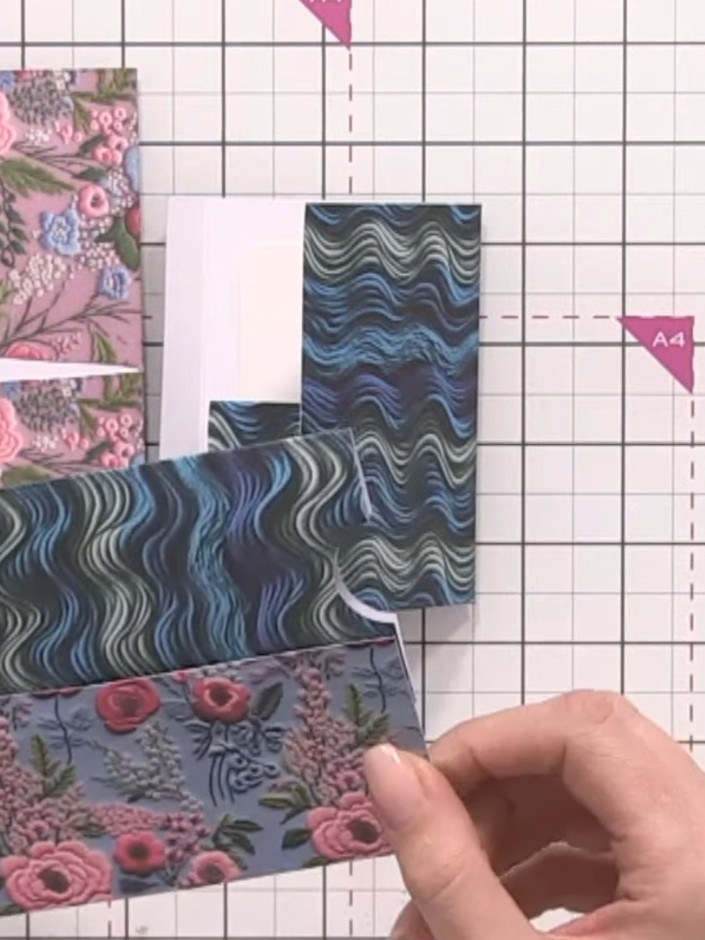 Step 5: Attach one tab punch to each end of your paper strip using adhesive tape to create pull-out handles for the po