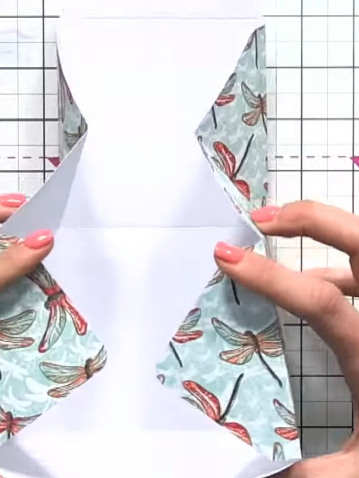 Step 11: Pinch the diagonal score lines to create the box's three-dimensional shape. The butterfly patterned paper shou