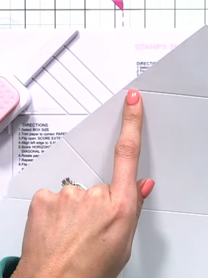 Step 8: Remove the four small triangle pieces from the corners of your scored paper. Line up the score lines on the to