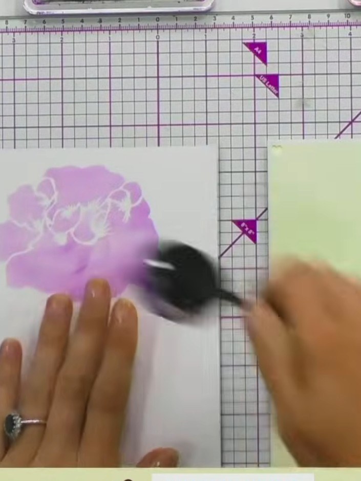 Step 3: Carefully remove the stencil from the card stock and set it aside. Allow the pink and purple ink to dry slight