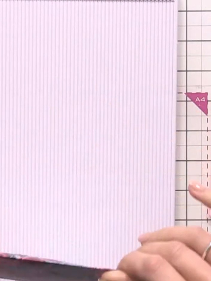 Step 3: Score a second sheet of pink striped paper at half an inch. Fold along the score line to create an interior pa