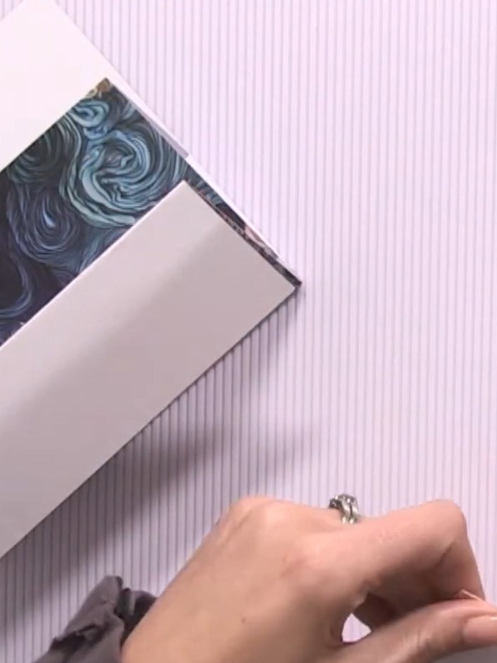 Step 7: Apply glue to the back cover hinge piece. Attach it to the back of your album structure, aligning it carefully