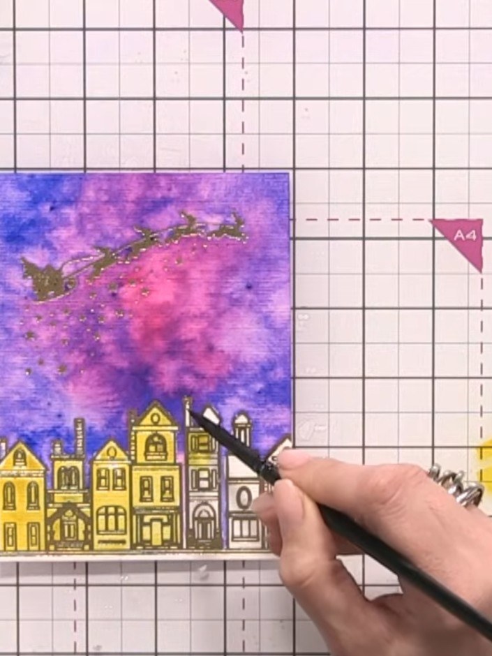 Step 8: Add orange watercolour to half of each building to create a lit effect, then apply a darker orange line down t