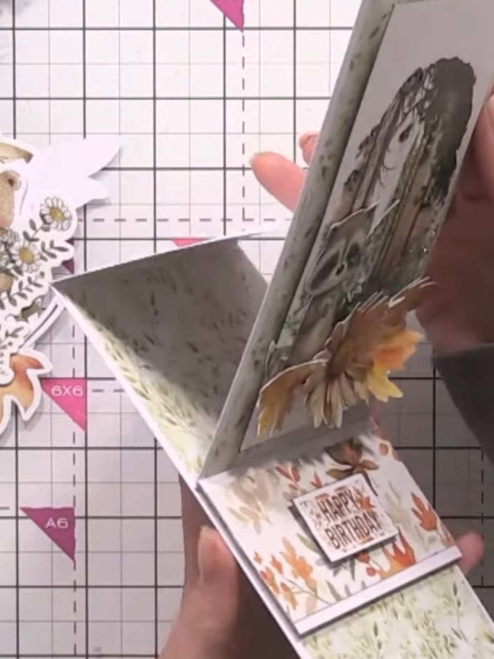 Step 16: Gently manipulate and curl the die-cut animal and leaf toppers to add dimension. Bend them slightly to create 