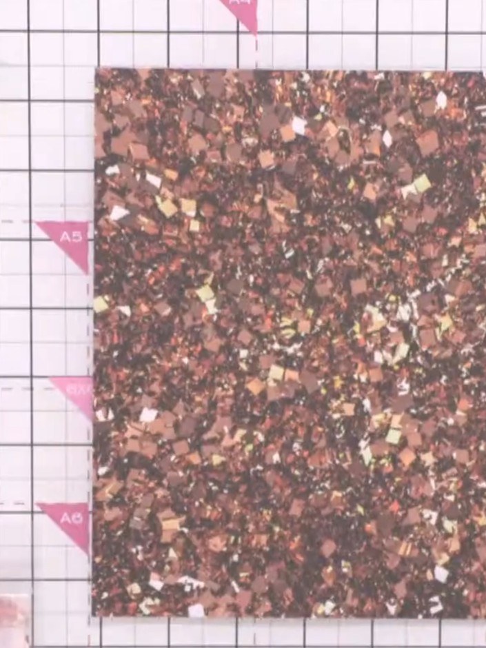 Step 1: Select a patterned paper with sparkly or glittery designs in festive colours such as bronze, copper, or gold. 