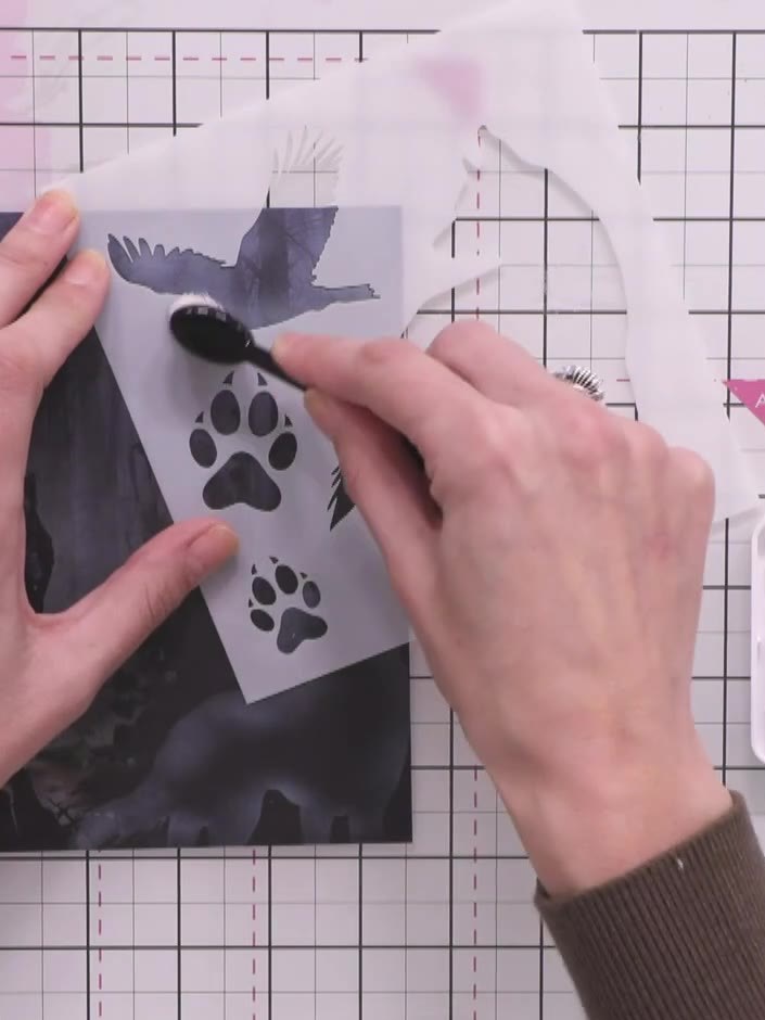 Step 8: Using the paw print stamp from the set and black ink, stamp two paw prints across the bottom portion of the ca
