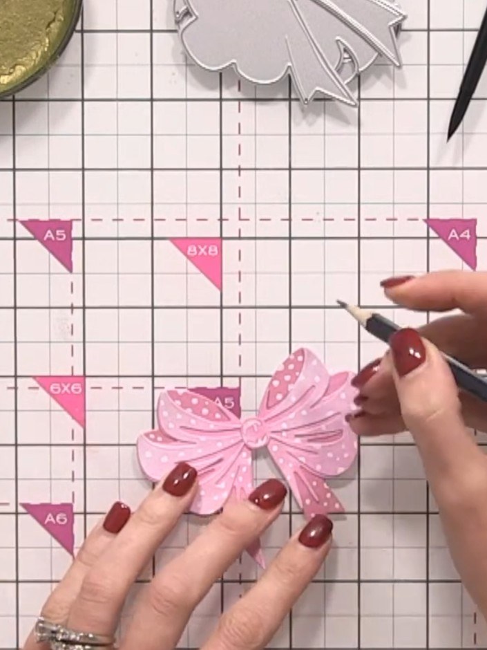 Step 10: Using a grey pencil, very lightly outline the edges of the pink bow to create a subtle shadow effect. Work aro