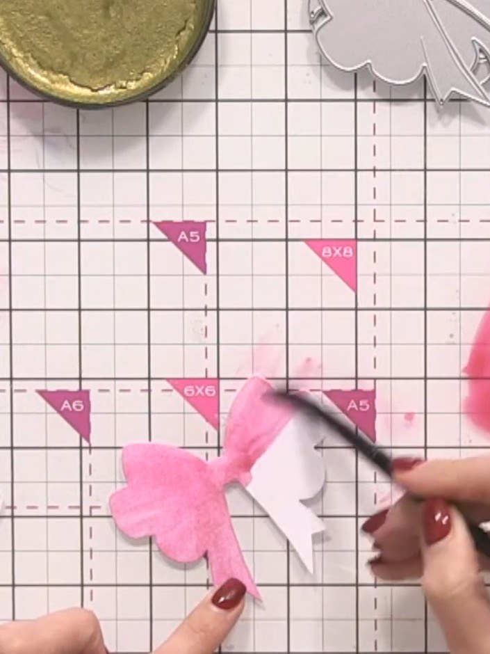 Step 5: Paint the middle bow piece with a lighter version of the pink by adding more water to dilute the colour. Apply